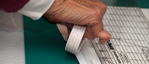 Inserting
                  double sided tape between fabric and backing so it
                  will feed in the Canon Pro-100 Color ink jet printer